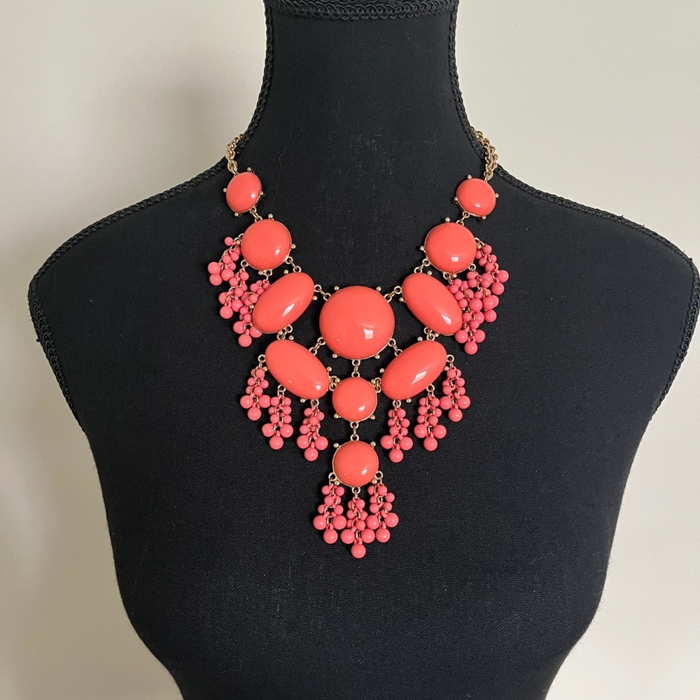 Coral coloured beaded necklace.
